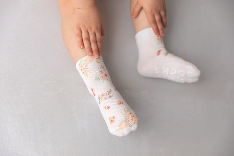 Chloe kids socks: child wearing white floral socks, with one sole visible. Squid Socks, the brand seen on Shark Tank.