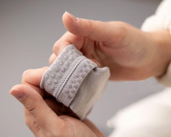 Classic kids socks: hand holding a folded cuff to show silicone grip dots. Squid Socks, the brand seen on Shark Tank.