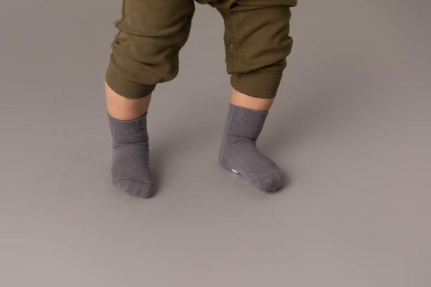 Classic kids socks: child standing in gray socks. Squid Socks, the brand seen on Shark Tank.