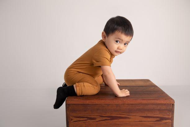 Coal kids socks: child on a wooden box wearing black socks. Squid Socks, the brand seen on Shark Tank.