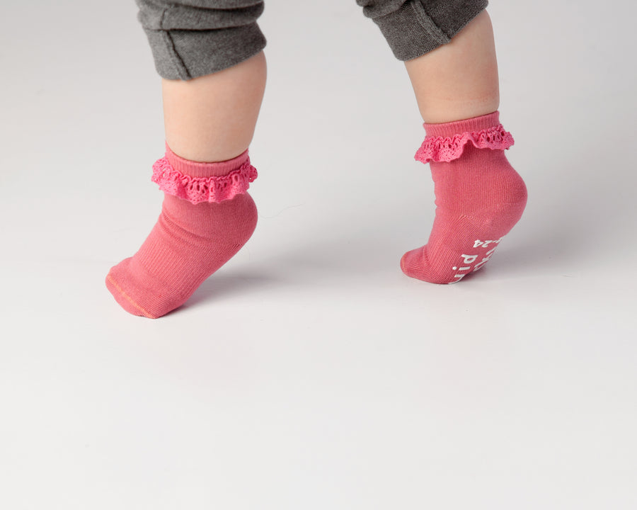 Charlotte kids socks: child standing on tiptoe in pink lace-trim socks. Squid Socks, the brand seen on Shark Tank.