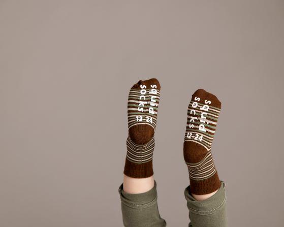 Chesney kids socks: child's raised feet showing brown striped sock soles. Squid Socks, the brand seen on Shark Tank.