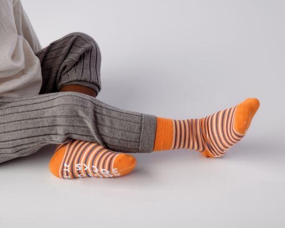 Colin kids socks: child wearing orange striped socks. Squid Socks, the brand seen on Shark Tank.