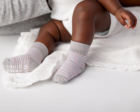 Christina kids socks: baby seated wearing pale gray striped socks. Squid Socks, the brand seen on Shark Tank.