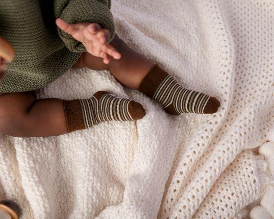 Chesney kids socks: baby lying on a blanket wearing brown striped socks. Squid Socks, the brand seen on Shark Tank.