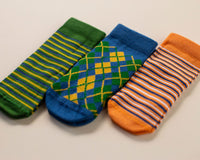 Colin kids socks: green and orange striped socks with a blue argyle sock. Squid Socks, the brand seen on Shark Tank.