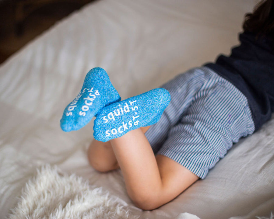 Chevy ankle socks: child lying down showing blue sock soles. Squid Socks, the brand seen on Shark Tank.