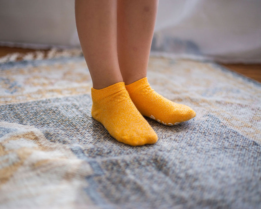 Chevy ankle socks: child standing in orange ankle socks. Squid Socks, the brand seen on Shark Tank.