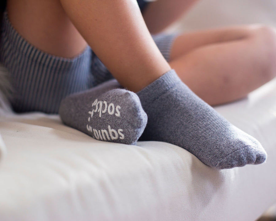 Crew ankle socks: child seated wearing gray ankle socks. Squid Socks, the brand seen on Shark Tank.