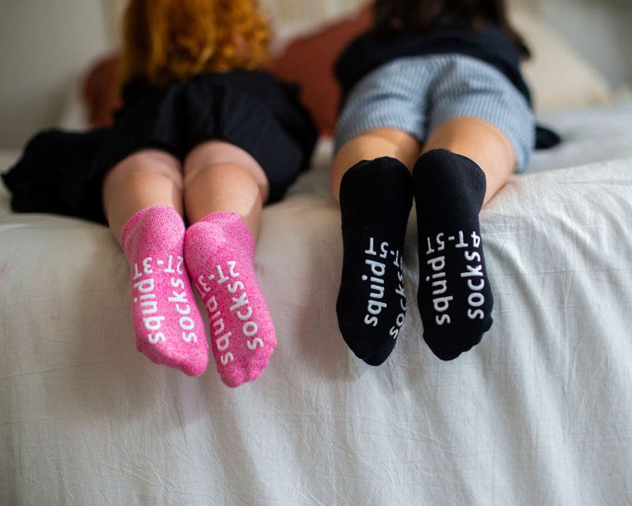 Clarissa ankle socks: two children showing pink and black sock soles. Squid Socks, the brand seen on Shark Tank.