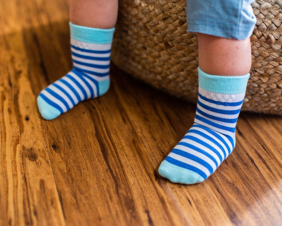 Cruz kids socks: child standing in blue striped socks. Squid Socks, the brand seen on Shark Tank.