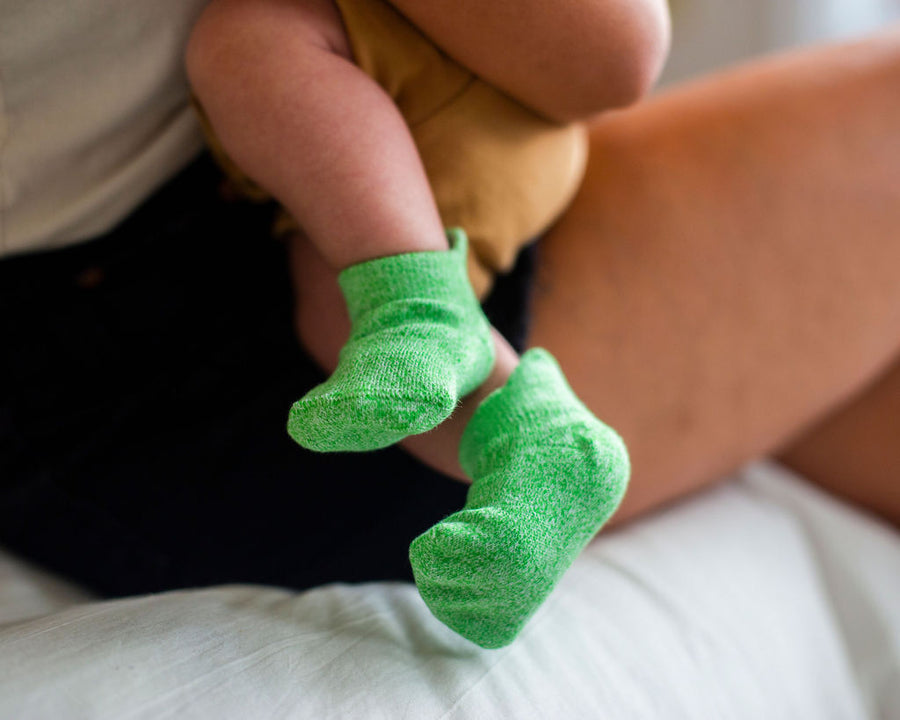 Chevy ankle socks: adult holding a baby wearing green ankle socks. Squid Socks, the brand seen on Shark Tank.