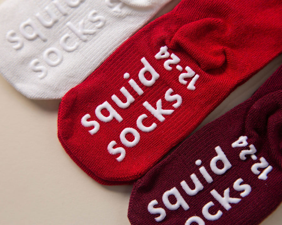 Channing kids socks: close-up of branded sole grips on red, cream and wine socks. Squid Socks, the brand seen on Shark Tank.