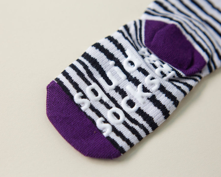 Chanel kids socks: close-up of branded sole grips on a purple zebra-print sock. Squid Socks, the brand seen on Shark Tank.