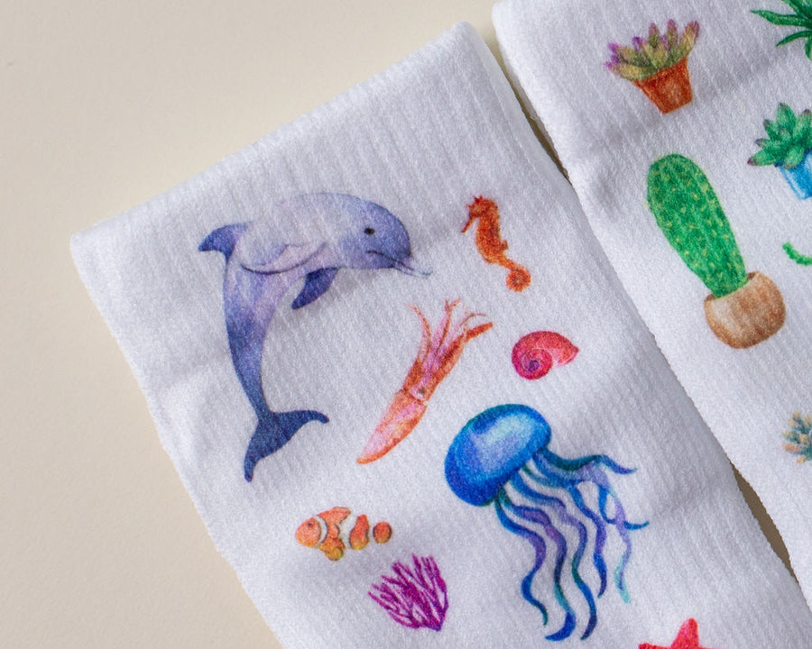 Caribbean kids socks: dolphin and jellyfish printed beside a cactus sock. Squid Socks, the brand seen on Shark Tank.