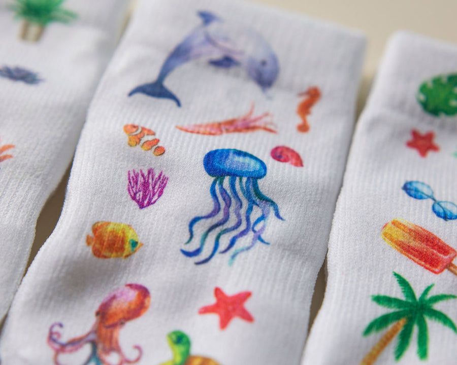 Caribbean kids socks: close-up of dolphin, jellyfish and other ocean illustrations. Squid Socks, the brand seen on Shark Tank.