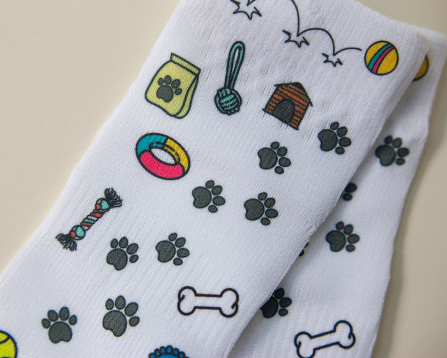 Woof kids socks: white socks with dog toys, paw prints and bones. Squid Socks, the brand seen on Shark Tank.