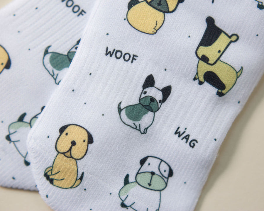 Woof kids socks: close-up of dog illustrations and woof lettering. Squid Socks, the brand seen on Shark Tank.