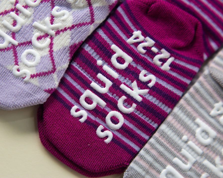 Christina kids socks: close-up of branded soles on magenta and lavender socks. Squid Socks, the brand seen on Shark Tank.